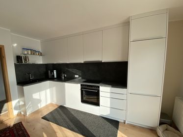 weiße Küche mit dunkelgrauer Betonoptik